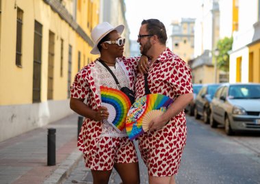 LGTBI bayrağı renginde el yelpazeli eşcinsel bir çift.