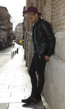 Sokakta deri ceketli ve kırmızı şapkalı genç bir manken.