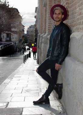Sokakta deri ceketli ve kırmızı şapkalı genç bir manken.