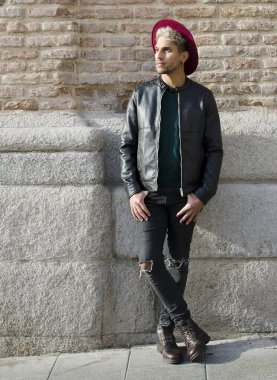 Sokakta deri ceketli ve kırmızı şapkalı genç bir manken.