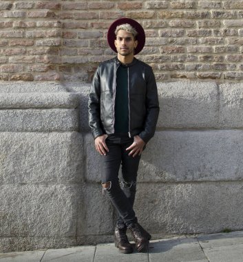 Sokakta deri ceketli ve kırmızı şapkalı genç bir manken.