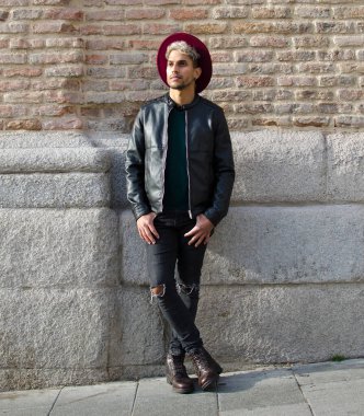 Sokakta deri ceketli ve kırmızı şapkalı genç bir manken.