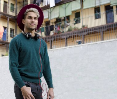 Kulaklıklı ve kırmızı şapkalı genç adam şehirde.