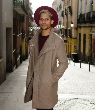 Gri ceketli ve kırmızı şapkalı genç manken.