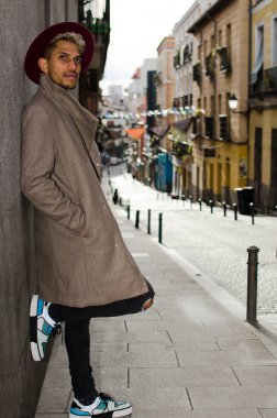 Gri ceketli ve kırmızı şapkalı genç manken.