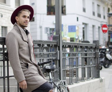 Gri ceketli ve kırmızı şapkalı genç manken.