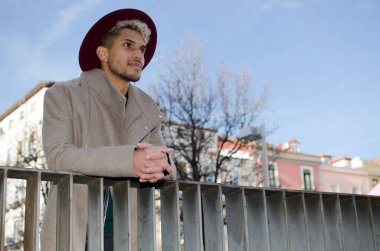 Gri ceketli ve kırmızı şapkalı genç manken.