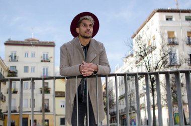 Gri ceketli ve kırmızı şapkalı genç manken.