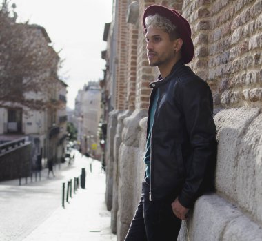 Sokakta deri ceketli ve kırmızı şapkalı genç bir manken.