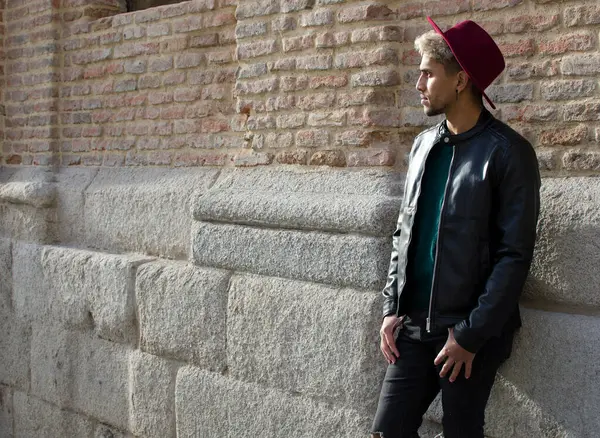 Sokakta deri ceketli ve kırmızı şapkalı genç bir manken.