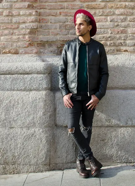 Sokakta deri ceketli ve kırmızı şapkalı genç bir manken.