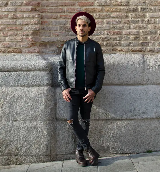 Sokakta deri ceketli ve kırmızı şapkalı genç bir manken.
