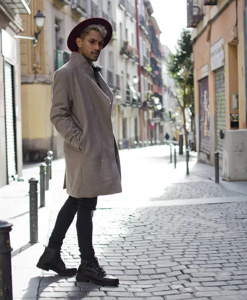 Gri ceketli ve kırmızı şapkalı genç manken.