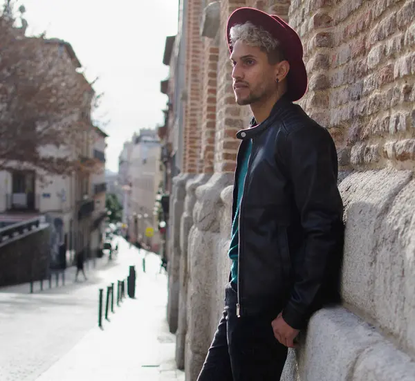 Sokakta deri ceketli ve kırmızı şapkalı genç bir manken.