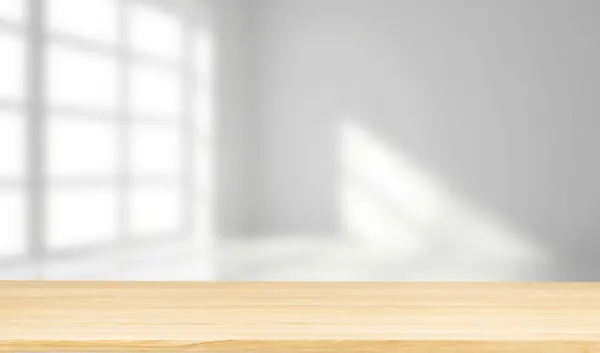 Ahşap zemini ve büyük beyaz beton duvarı olan modern boş bir oda.