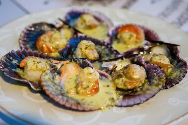 Zeytinyağı, sarımsak ve maydanozlu ızgara deniz tarağı. Galiçya usulü deniz tarağı yemeği Vieira. Tipik Zamburias yemeği Galiçya, İspanya, leziz İspanyol yemekleri.