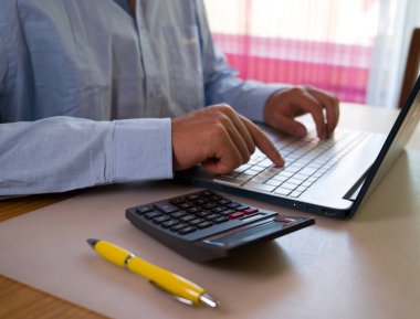 Bilgisayarın klavyesinde yazı yazan adam eli, ofiste dizüstü bilgisayar kullanan iş adamı veya öğrenci, çevrimiçi öğrenme, internet pazarlaması, evden çalışma, ofis iş yeri serbest kavramı