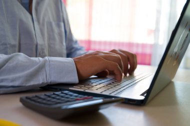 Bilgisayarın klavyesinde yazı yazan adam eli, ofiste dizüstü bilgisayar kullanan iş adamı veya öğrenci, çevrimiçi öğrenme, internet pazarlaması, evden çalışma, ofis iş yeri serbest kavramı