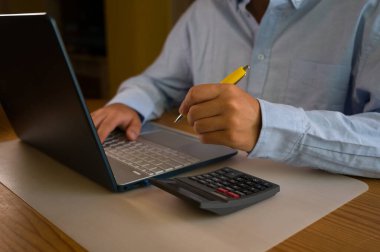 Bilgisayarın klavyesinde yazı yazan adam eli, ofiste dizüstü bilgisayar kullanan iş adamı veya öğrenci, çevrimiçi öğrenme, internet pazarlaması, evden çalışma, ofis iş yeri serbest kavramı