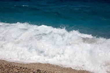 waves of the sea breaking on the shore with foam