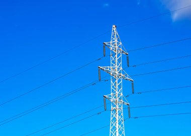 Elektrik şebekesi, yüksek gerilimli elektrik hatları. Güneşli bir günde elektrik dağıtım sisteminin bir parçası..