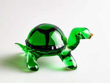 A figurine of a green turtle, specially made of glass on a white background. clipart