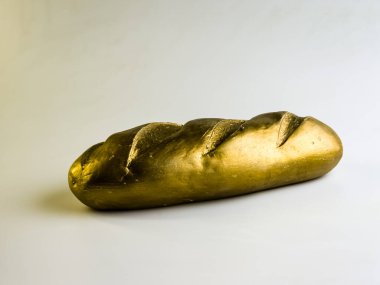 Altın somun. Beyaz arka planda bir ekmek somunu şeklinde kumbara. Yan görünüm