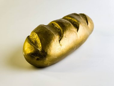 Altın somun. Beyaz arka planda bir ekmek somunu şeklinde kumbara. Açılı görünüm