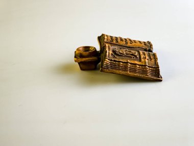 Dini bir şamdan, açık bir incil şeklinde ve beyaz arka planda bir mum için bir yer. Bakırdan yapılmış. Yan görüş. Kilise aletleri..