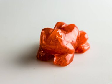Carnelian kurbağası beyaz arka planda iyi şans getiriyor..