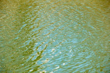 Gün batımı ışınlarında su yüzeyi, nehir dalgaları ya da küçük dalgalı okyanus, sakin ve yakın çekim. Doğal arka plan. Soyut arkaplan.