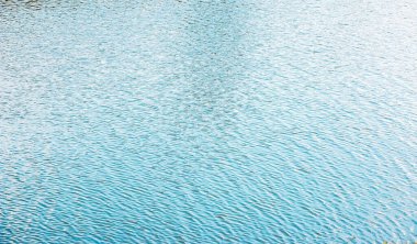 Gün batımında su yüzeyi, küçük dalgalı nehir dalgaları, sakin ve yakın çekim. Doğal arka plan. Soyut doku.