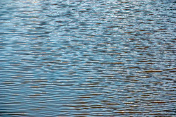 Su yüzeyi, nehir dalgaları ya da küçük dalgalı okyanus, sakin ve yakın çekim. Soyut arkaplan, doku.