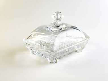 Beyaz arkaplanda tereyağı depolamak için cam kap.