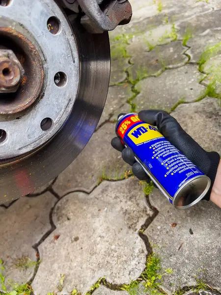 Araba bakımı. VD 40 ile eklemler ve fren bağlantıları inceleniyor. Eldivende silindir var..