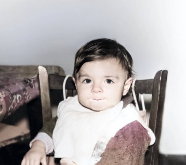 Bir yaşında yemek yiyen bir kızın klasik portresi. Çocuğun ağzı lapanın içinde. 1995 'ten kalma eski bir fotoğraf.