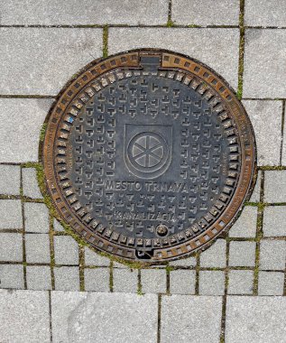 Trnava, Slovakya - 17.04.2025: Metal kanallı taş taşlama. Arkaplan dokusu olarak taş kaldırım. Taş bloklardan yapılmış yol yüzeyi.