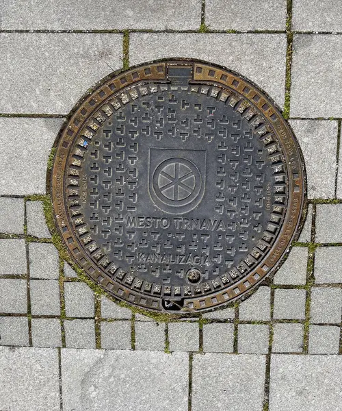 Trnava, Slovakya - 17.04.2025: Metal kanallı taş taşlama. Arkaplan dokusu olarak taş kaldırım. Taş bloklardan yapılmış yol yüzeyi.