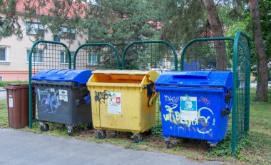 Nitra, Slovakya - 05.21.2025: Sokaktaki çöp bidonları. Çevreyle ilgilenmek, çöpleri farklı kaplara ayırmak.