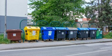 Nitra, Slovakya - 05.21.2025: Sokaktaki çöp bidonları. Çevreyle ilgilenmek, çöpleri farklı kaplara ayırmak.