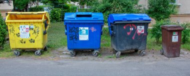 Nitra, Slovakya - 05.21.2025: Sokaktaki çöp bidonları. Çevreyle ilgilenmek, çöpleri farklı kaplara ayırmak. Yakın plan..