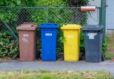 Nitra, Slovakya - 05.21.2025: Geri dönüşüm için farklı renkli çöp kutuları. Çevreyle ilgilenmek, çöpleri farklı kaplara ayırmak..