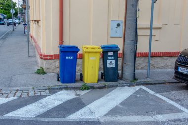 Nitra, Slovakya - 05.21.2025: Geri dönüşüm için farklı renkli çöp bidonları.