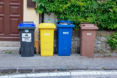 Nitra, Slovakya - 05.21.2025: Geri dönüşüm için farklı renkli çöp bidonları.