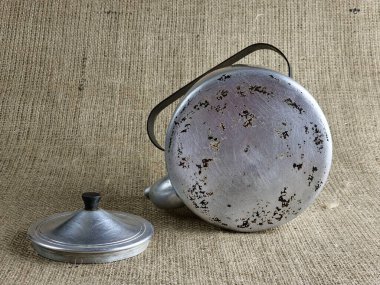 İkinci Dünya Savaşı 'ndan kalma alüminyum ordu çaydanlığı. Dibe dışarıdan bir bakış. Sovyet askerinin çaydanlığı. Yakın plan. Çuval bezi arka planı.