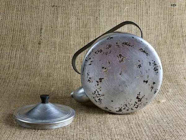 İkinci Dünya Savaşı 'ndan kalma alüminyum ordu çaydanlığı. Dibe dışarıdan bir bakış. Sovyet askerinin çaydanlığı. Yakın plan. Çuval bezi arka planı.