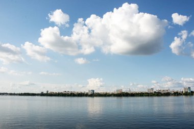 Dinyeper Nehri 'nin sol kıyısının panoramik manzarası. Ukrayna. Dinyeper şehri. Su yüzeyinde bulutlu gökyüzünün yansıması..