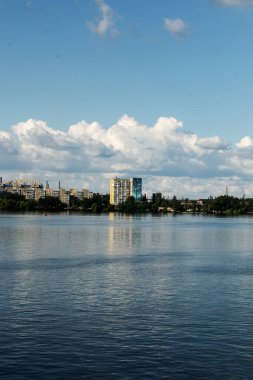Dinyeper Nehri 'nin sol kıyısının panoramik manzarası. Ukrayna. Dinyeper şehri. Su yüzeyinde bulutlu gökyüzünün yansıması..