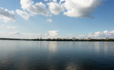 Dnepr şehrinin panoramik görüntüsü. Ukrayna. Su yüzeyinde bulutlu gökyüzünün yansıması..