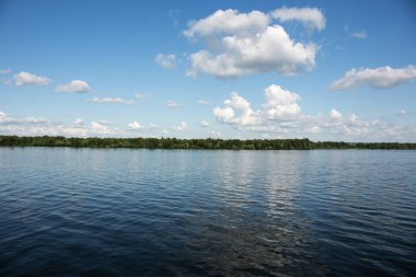 Dinyeper nehri kıyısının panoramik manzarası Dinyeper şehrinin setinden. Suyun yüzeyinde bulutlu gökyüzünün yansıması..